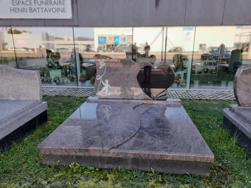 Grand monument funéraire en granit moucheté poli avec stèle en cœur et gravure.